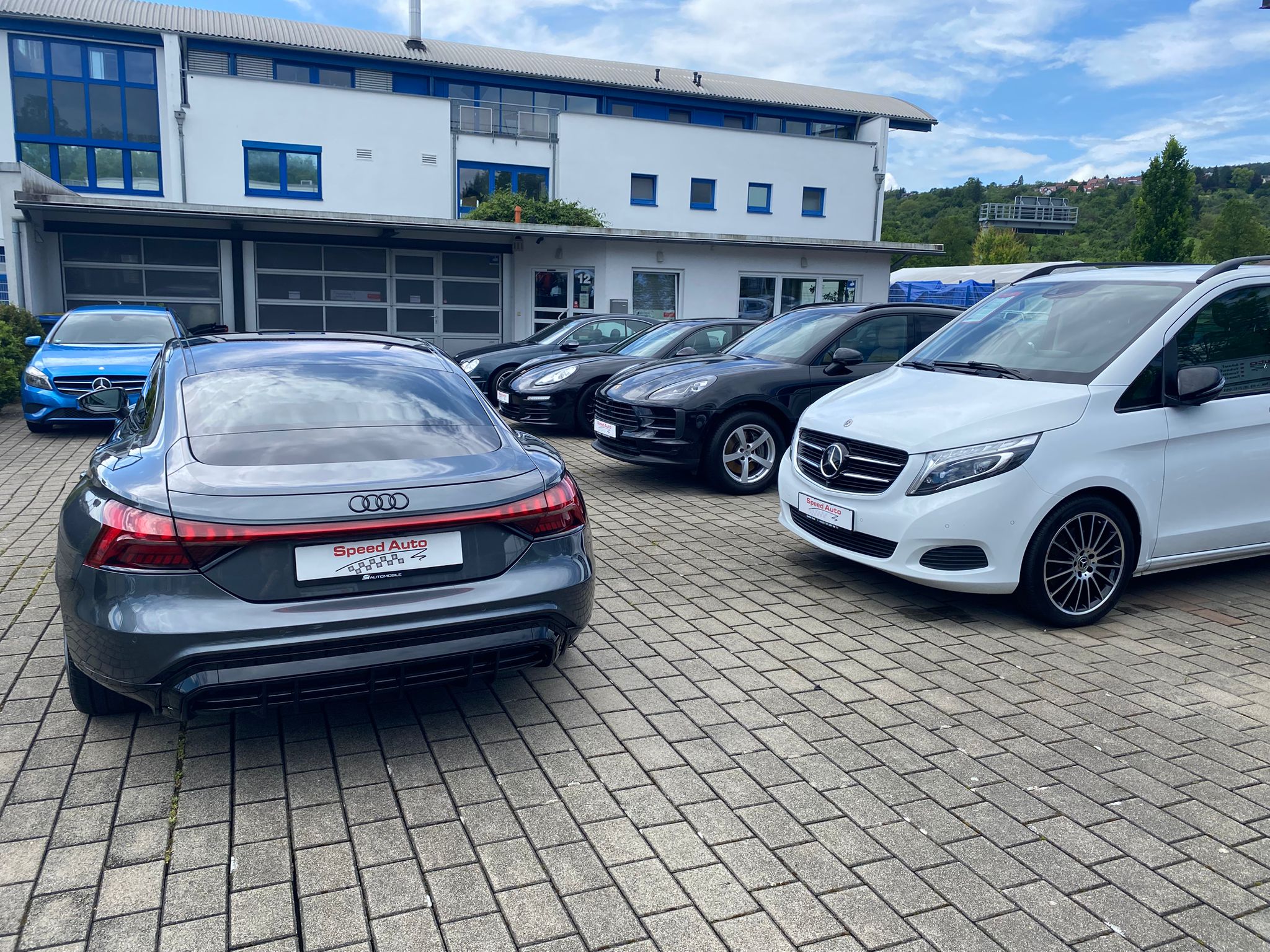 Audi und Mercedes sowie weitere Fahrzeuge vor dem Gebäude