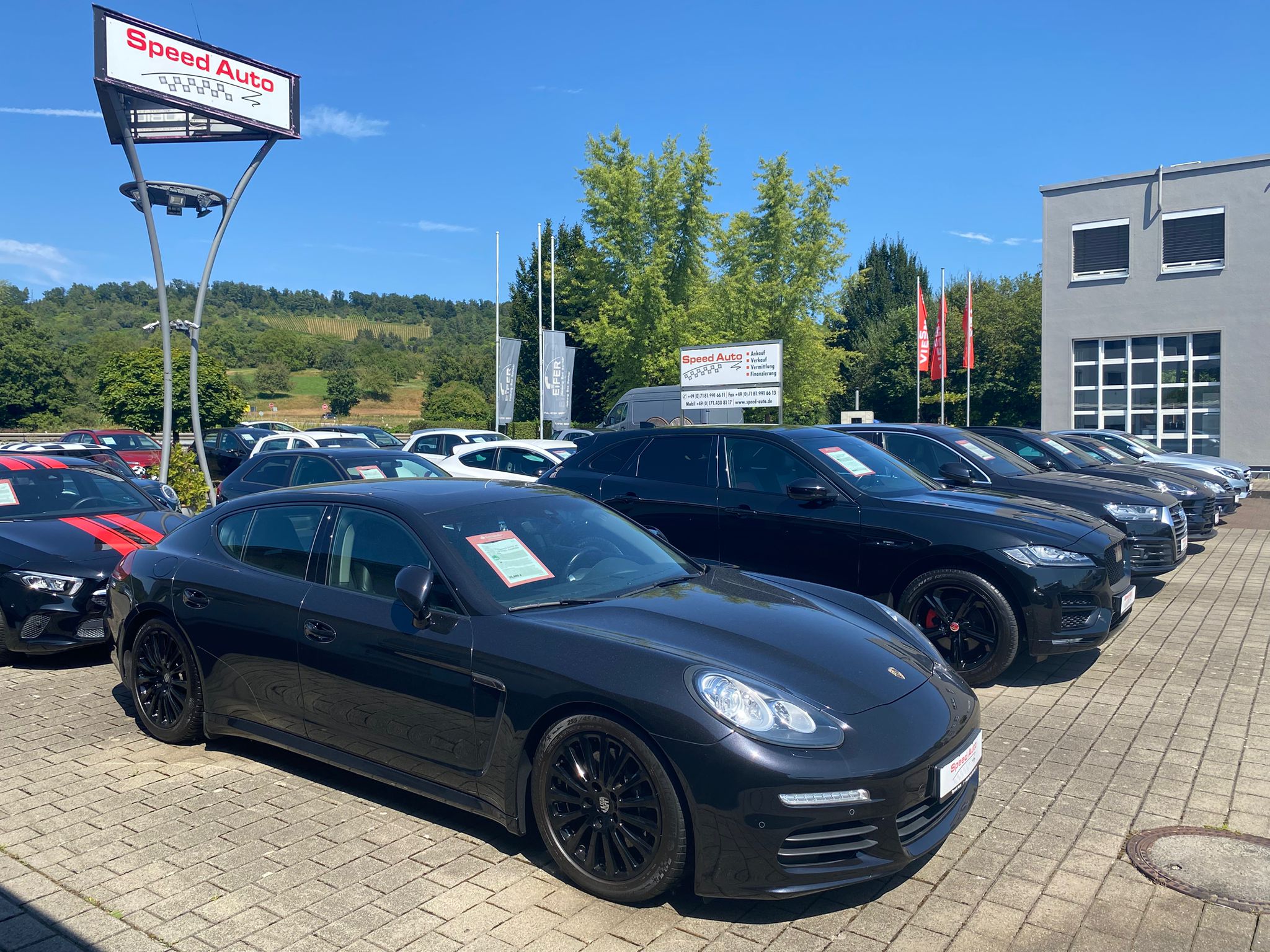 Fahrzeugreihe bei Sonnenschein mit Speed Auto Schild